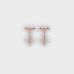 Rose gold earrings on a light gray background